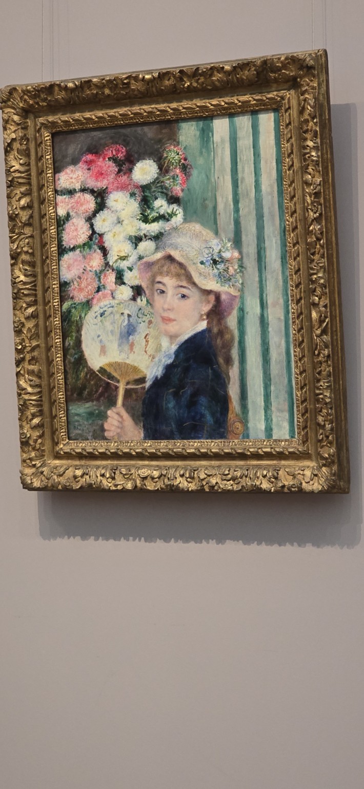 A hanging impressionist painting of "Woman with a Fan" by  Pierre-Auguste Renoir